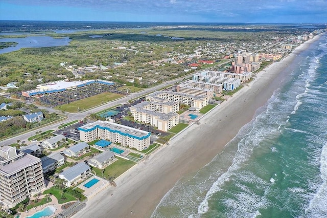 drone / aerial view featuring a water view and a beach view