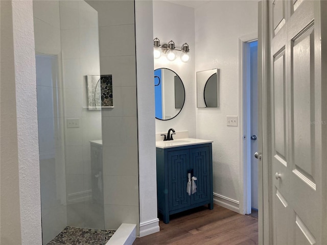 bathroom featuring wood-type flooring, a shower, and vanity