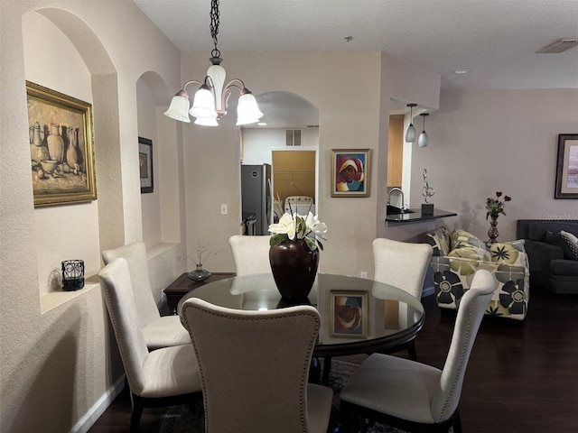 dining room featuring sink, dark wood-type flooring, and a textured ceiling