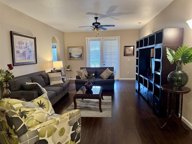 living room featuring a textured ceiling, dark hardwood / wood-style floors, and ceiling fan