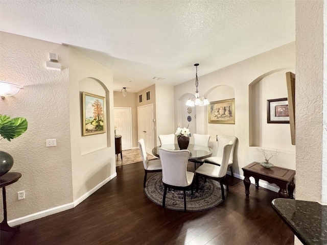 dining area with dark hardwood / wood-style floors and a textured ceiling