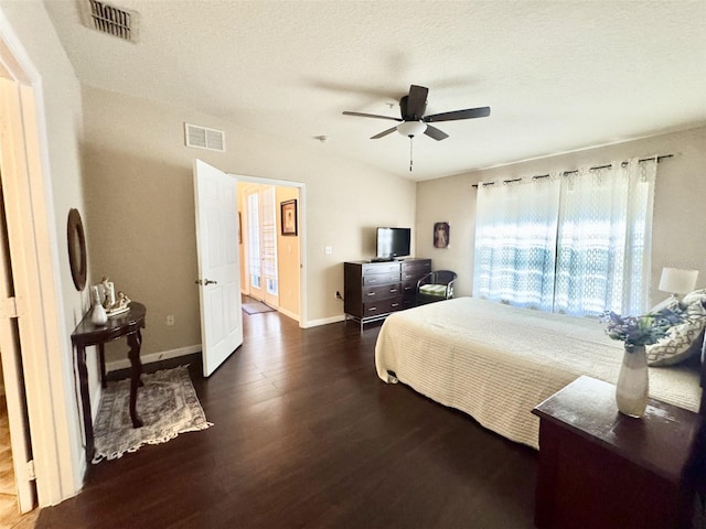 bedroom with ceiling fan, a textured ceiling, and dark hardwood / wood-style floors