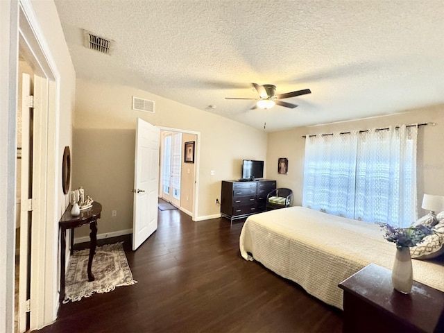 bedroom with dark wood-type flooring, a textured ceiling, and ceiling fan