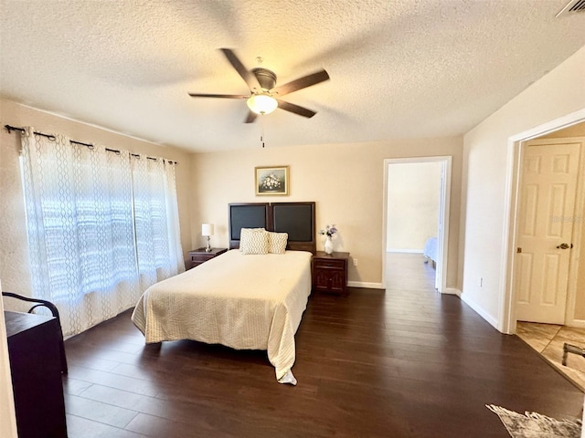 bedroom featuring ceiling fan, a textured ceiling, and dark hardwood / wood-style floors