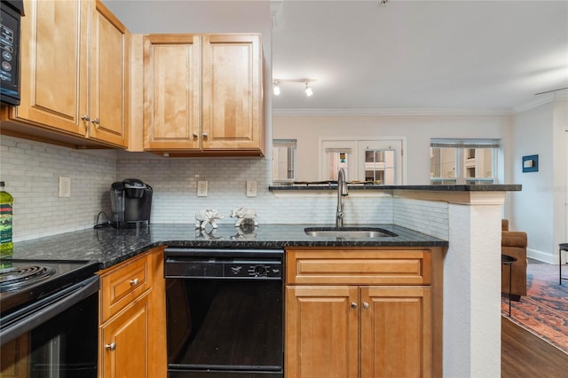 kitchen featuring black dishwasher, crown molding, dark stone counters, sink, and backsplash