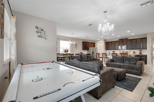 rec room with light tile patterned flooring and an inviting chandelier