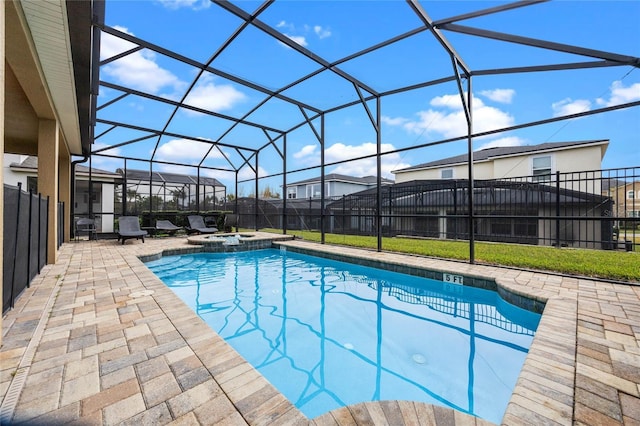 view of swimming pool with glass enclosure, an in ground hot tub, and a patio