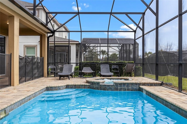 view of pool with an in ground hot tub, a patio area, and glass enclosure