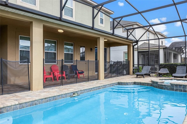 view of swimming pool featuring a patio, glass enclosure, and an in ground hot tub