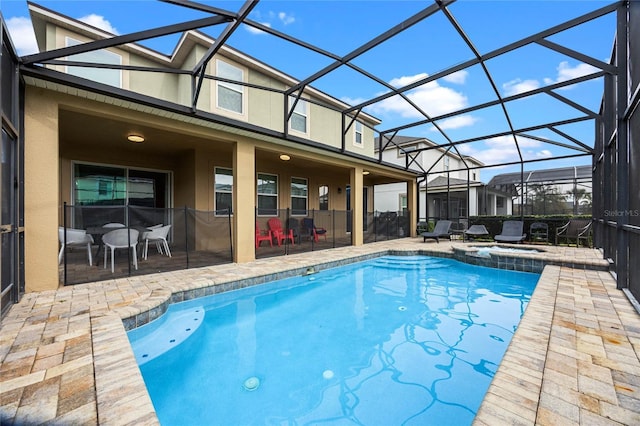 view of swimming pool with glass enclosure, a patio area, and an in ground hot tub