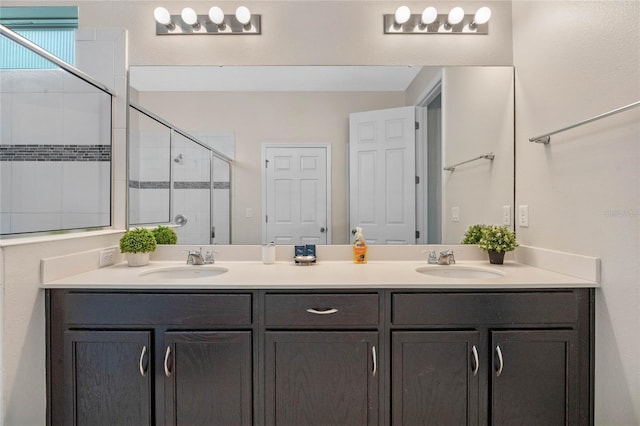 bathroom featuring a shower with door and vanity