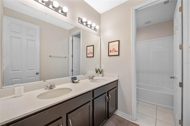 bathroom featuring tiled shower / bath, tile patterned floors, and vanity