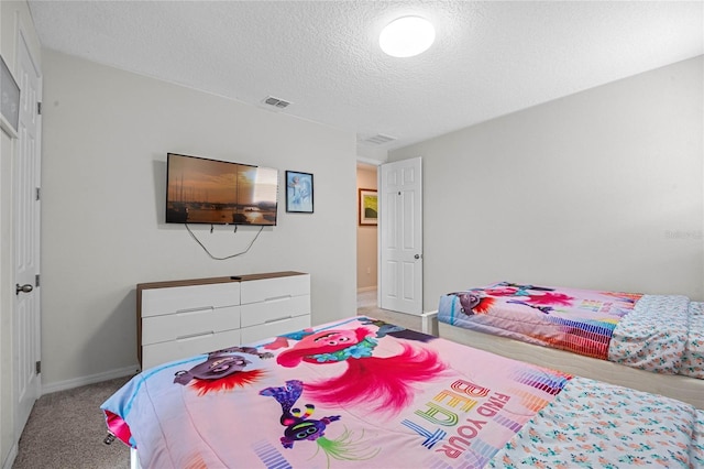 bedroom with carpet floors and a textured ceiling