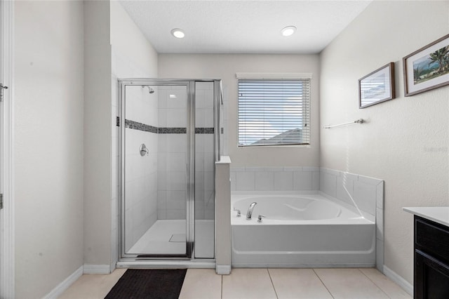 bathroom featuring a textured ceiling, tile patterned flooring, separate shower and tub, and vanity