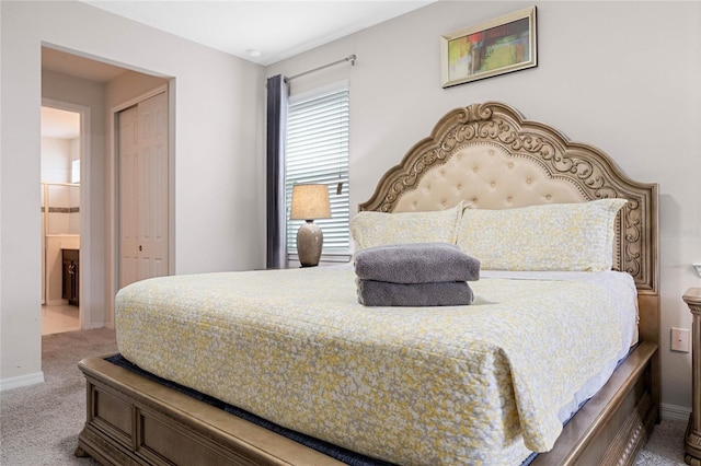 bedroom with carpet, a closet, and ensuite bath