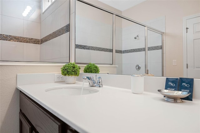 bathroom featuring vanity and a shower with door