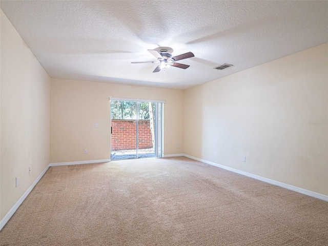 carpeted empty room with ceiling fan and a textured ceiling