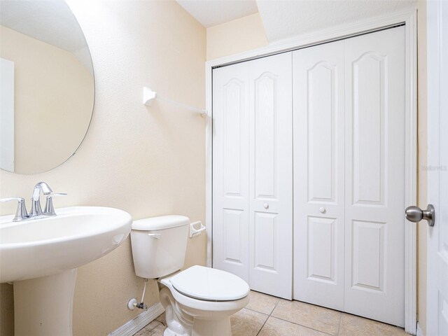 bathroom featuring sink, tile patterned floors, and toilet