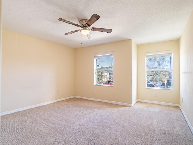 carpeted spare room with ceiling fan and a textured ceiling