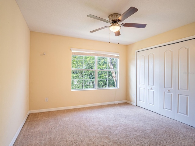 unfurnished bedroom featuring ceiling fan, carpet flooring, and a closet