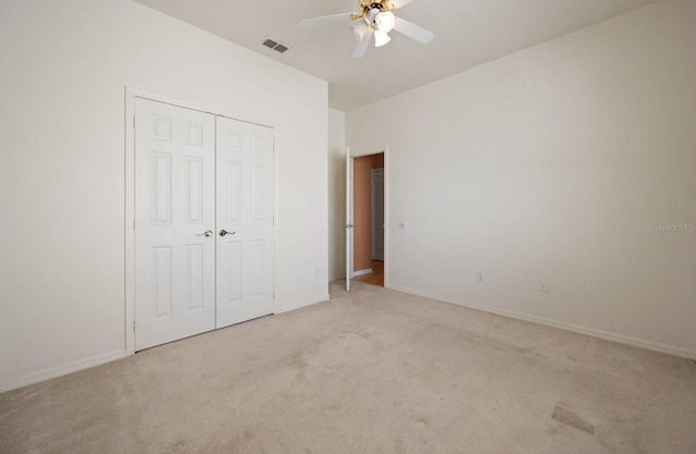 unfurnished bedroom with light colored carpet, a closet, and ceiling fan