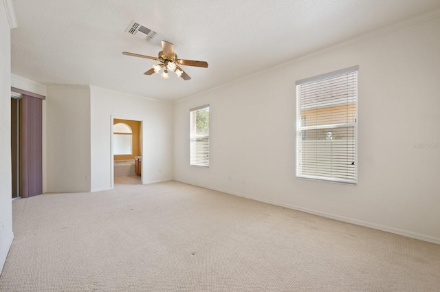 spare room with light carpet, ceiling fan, and ornamental molding