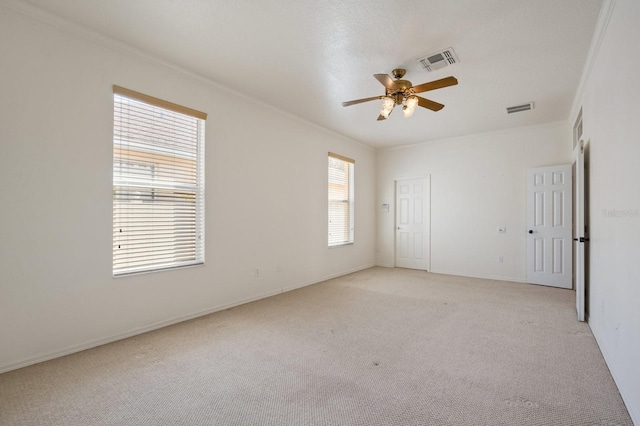 carpeted spare room with ceiling fan and ornamental molding