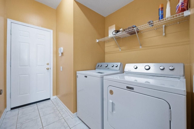 laundry area featuring washing machine and dryer and light tile patterned floors