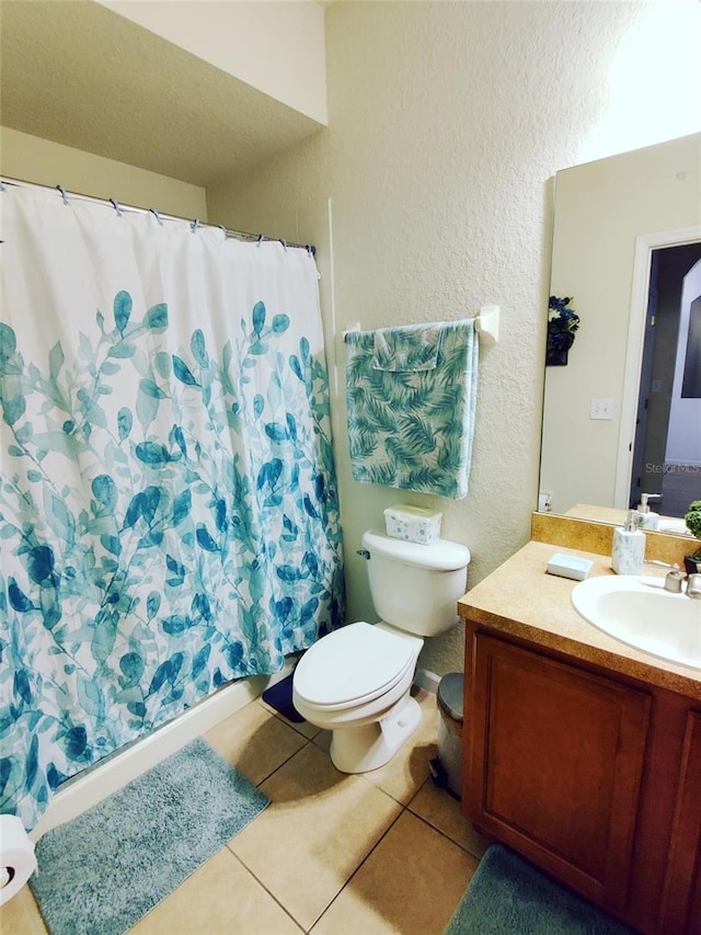 bathroom with toilet, tile patterned flooring, and vanity