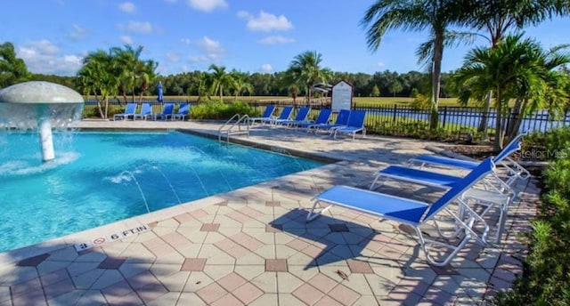 view of swimming pool with pool water feature and a patio