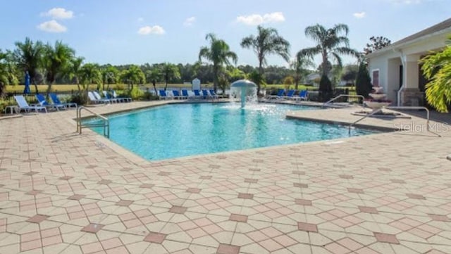 view of pool with pool water feature and a patio