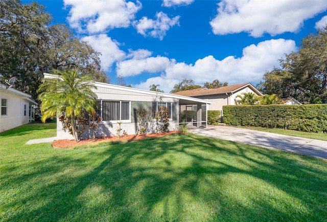 view of front of house featuring a front yard, a carport, and a sunroom