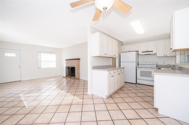 kitchen with sink, white appliances, a fireplace, white cabinets, and light tile patterned flooring