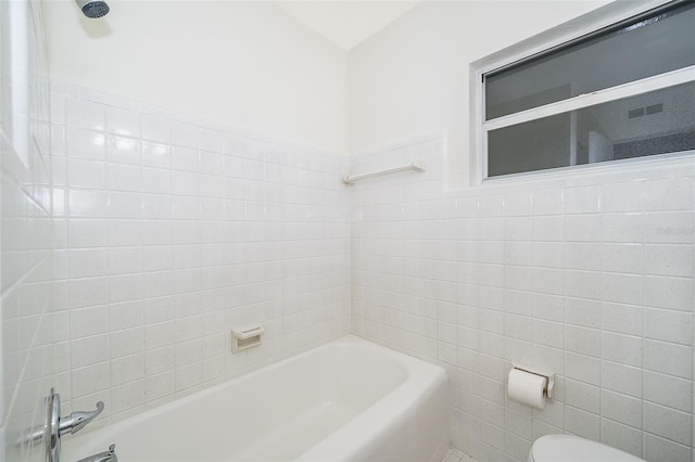 bathroom with tile walls and toilet