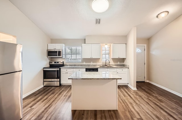 kitchen featuring white cabinetry, appliances with stainless steel finishes, light stone countertops, and sink