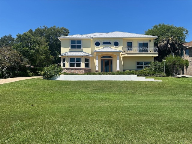 view of front facade with a front yard and a balcony