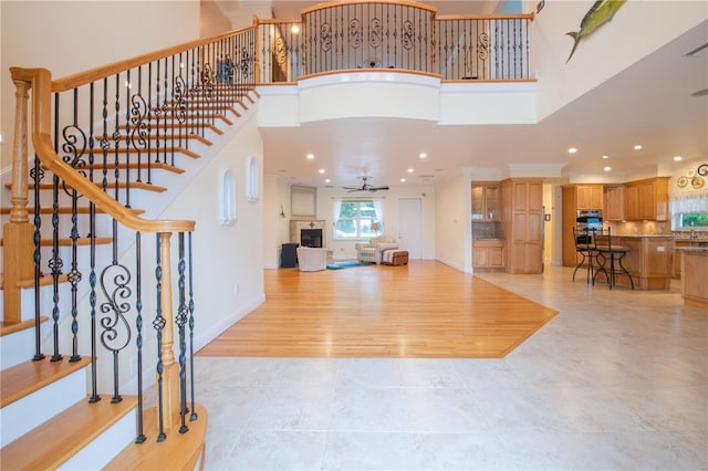 entrance foyer featuring a towering ceiling and ceiling fan