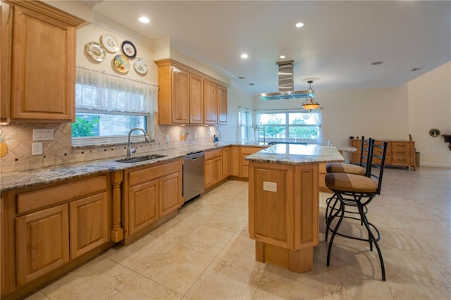 kitchen featuring pendant lighting, sink, a center island, stainless steel dishwasher, and light stone countertops