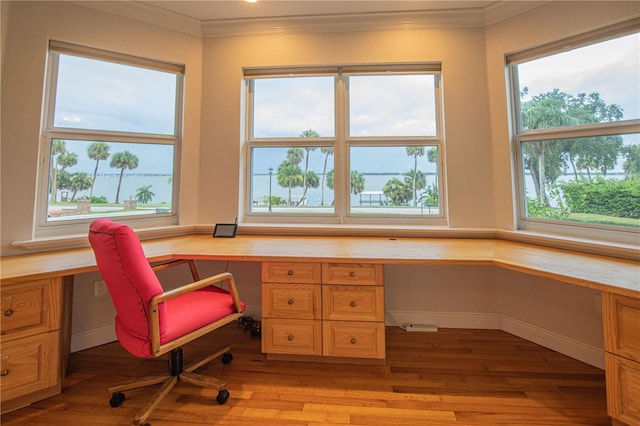 office area with crown molding, built in desk, and light wood-type flooring