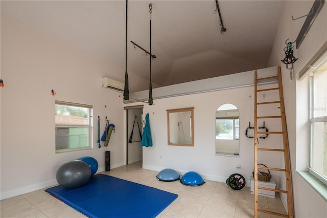 workout area featuring an AC wall unit, high vaulted ceiling, and rail lighting