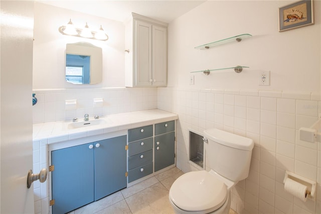 bathroom with tile patterned flooring, vanity, tile walls, and toilet