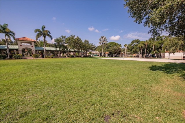 surrounding community with a yard and volleyball court