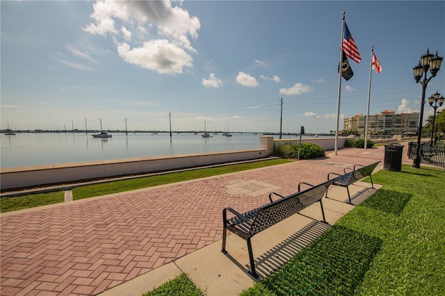 surrounding community with a lawn and a water view