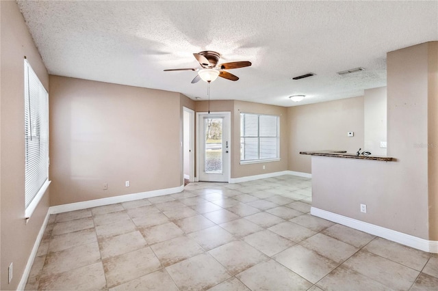 unfurnished room featuring a textured ceiling and ceiling fan