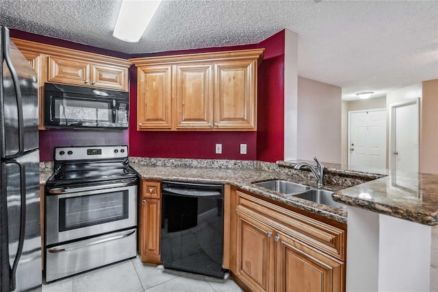 kitchen featuring sink, a textured ceiling, light tile patterned floors, kitchen peninsula, and black appliances