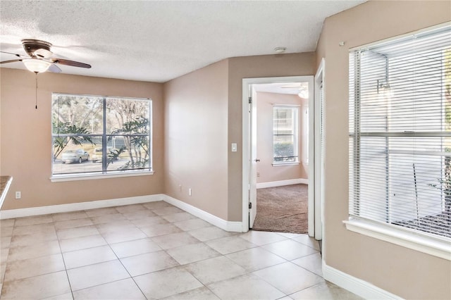 tiled spare room with ceiling fan and a textured ceiling