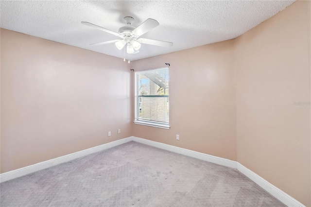 empty room with light colored carpet, a textured ceiling, and ceiling fan