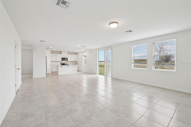 unfurnished living room featuring a wealth of natural light, visible vents, and recessed lighting