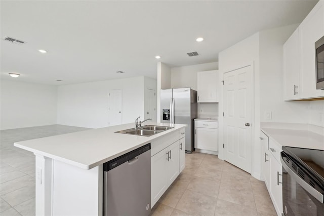 kitchen with a sink, white cabinetry, light countertops, appliances with stainless steel finishes, and an island with sink