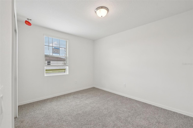 spare room with carpet floors and baseboards